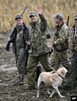 FILE - Democratic Presidential candidate Senator John Kerry, D-Mass., second from left, waves as he returns from a goose hunting trip in Poland, Ohio, Oct. 21, 2004.