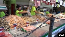 Seafood sellers at Captain White's Seafood City in Washington, DC measure different amount of their products for customers.