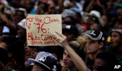 FILE - A student holds a placard during their protest against university tuition hikes outside the ruling party African National Congress (ANC) headquarters in Johannesburg, South Africa, Oct. 22, 2015.