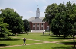 In this July 8, 2014 picture, people walk on Johns Hopkins University's Homewood campus in Baltimore.