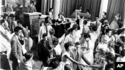 Dick Clark, at upper left, is surrounded by teenage fans on his nationally televised dance show "American Bandstand" in 1958
