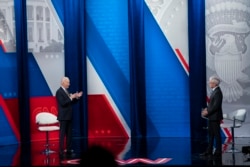 Anderson Cooper (kanan) mendengarkan Presiden Joe Biden saat menjawab pertanyaan dalam siaran langsung yang disiarkan melalui televisi di Pabst Theatre, Milwaukee, Selasa, 16 Februari 2021. (Foto AP / Evan Vucci)