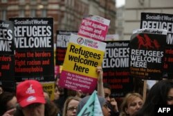 Pro-refugee activists rally with placards outside the French Embassy in central London after an aid convoy headed to northern France was turned back at the port of Dover, June 18, 2016.