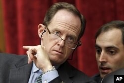 FILE - Sen. Patrick Toomey, R-Pa., left, confers with an aide, on Capitol Hill.