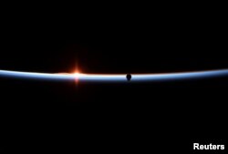 FILE - The SpaceX Crew Dragon capsule approaches in a photograph taken by NASA astronaut Anne McClain aboard the International Space Station, March 3, 2019.