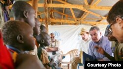 Rep. Chris Smith, R-NJ, and Rep. Karen Bass, D-CA, talk to South Sudanese children from refugee camps during a trip in May of 2017.