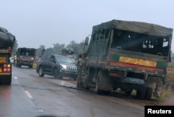 Soldiers stand beside military vehicles just outside Harare, Zimbabwe, Nov. 14, 2017.