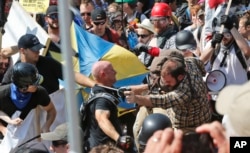 FILE - White nationalist demonstrators clash with counterdemonstrators at the entrance to Lee Park in Charlottesville, Va., Aug. 12, 2017.