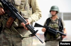 FILE - Turkish soldiers stand guard at a checkpoint on the main road between Mardin and Cizre in southeastern Turkey, Sept. 9, 2015. At the time, Turkey's southeast had seen almost daily clashes between militants from the outlawed Kurdistan Workers' Party (PKK) and security forces for several months.