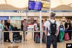 A British tourist looks at a flight information panel at the airport of Sharm el-Sheikh, Egypt, Nov. 7, 2015.