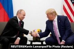 Arhiva - Predsjednik Rusije Vladimir Putin rukuje se sa predsjednikom SAD Donaldom Trumpom, tokom bilateralnog sastanka na marginama samita idera G20, u Osaki, Japan, 28. juna 2019.