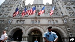 FILE - Law enforcement officers stand guard in front of the Trump Hotel in Washington, June 30, 2018.