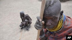 FILE - In this Aug. 30, 2011 photo, an elderly woman and her husband wait during a famine for the distribution of food from Oxfam, in central Turkana district, Kenya.