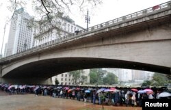Unemployed people line up to fill out applications while looking for job opportunities in downtown Sao Paulo, Brazil, Aug. 6, 2018.