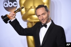 Emmanuel Lubezki poses with the award for best cinematography for “The Revenant” in the press room at the Oscars on Feb. 28, 2016, at the Dolby Theatre in Los Angeles.