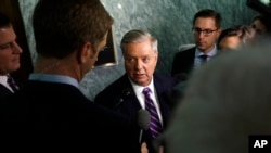 FILE - Republican Sen. Lindsey Graham, center, talks to reporters on Capitol Hill in Washington, Sept. 14, 2017.