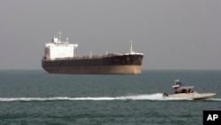 FILE - An Iranian Revolutionary Guard speedboat passes near an oil tanker, July 2, 2012.