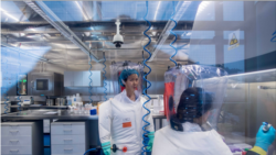 virologia kineze Shi Zhengli (majtas) shquhet brenda kostumit mbrojtës në laboratorin e Wuhanit (23 shkurt 2017)