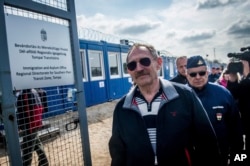 FILE - Hungarian Interior Minister Sandor Pinter, foreground, inspects the enlarged transit zone set up for migrants at the country's southern border with Serbia near Tompa, 169 kms southeast of Budapest, April 6, 2017.