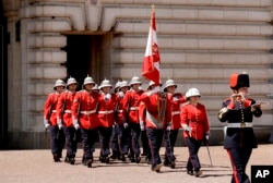 Canadian Captain Megan Couto, second right, makes history by becoming the first female Captain of the Queen's Guard as she takes part in the Changing the Guard ceremony at Buckingham Palace in London, Monday, June 26, 2017.