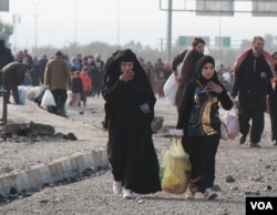 As women flee IS in Mosul, Iraq, many flip back the veils the militant group requires them to wear on their faces, Jan. 14, 2017. (H. Murdock/VOA)