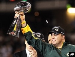 Packers head coach Mike McCarthy holds up the Vince Lombardi Trophy after the Packers defeated the Steelers in the NFL's Super Bowl XLV football game in Arlington, Texas, February 6, 2011
