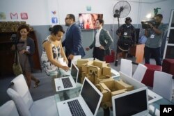 Google's head of Cuba operations, Brett Perlmutter, center right, and Alexis Leiva Machado, a Cuban sculptor known as Kcho, center left, walk inside the new Google technology center which will offer free Internet access in Havana, Cuba, March 21, 2016.