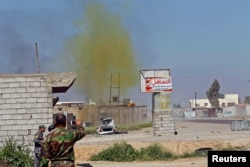 FILE - A chlorine-tinged cloud of smoke rises into the air from an alleged Islamic State bomb that was detonated by Iraqi army and Shi'ite fighters, in the town of al-Alam in Salahuddin province, March 10, 2015.