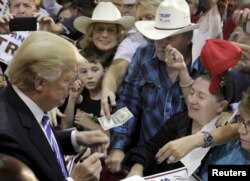 U.S. Republican presidential candidate Donald Trump leaves the stage after a campaign rally at the Richmond International Raceway in Richmond, Virginia, Oct. 14, 2015.