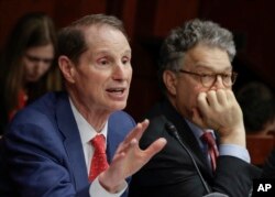 FILE - Sen. Ron Wyden, D-Ore., left, with Sen. Al Franken, D-Minn., join other Democratic senators at a hearing hosted by the Democratic Policy and Communications Committee about how the GOP health care bill could hurt rural Americans, at the Capitol in Washington, June 21, 2017.