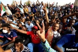 Sudanese demonstrators cheer as they attend a protest rally demanding Sudanese President Omar Al-Bashir to step down outside the Defense Ministry in Khartoum, Sudan, April 11, 2019.