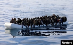 FILE - Migrants are seen in a rubber dinghy as they are rescued by the Libyan coast guard in the Mediterranean Sea off the coast of Libya, Jan. 15, 2018.