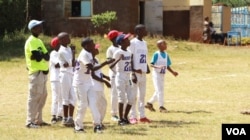 Coach Chapman Owino and some of his Kilimanjaro All-Stars watch the action. (L. Ruvaga/VOA)