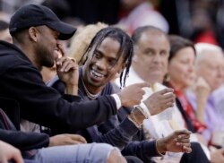 Artis rap Travis Scott, tengah, bereaksi selama pertandingan bola basket NBA antara Houston Rockets dan Denver Nuggets di Houston, 5 April 2017. (Foto: AP)