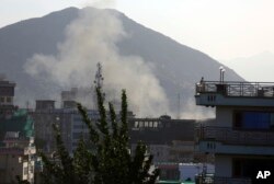 Smoke rises from the site of the second deadly suicide attack on police stations in one day, May 9, 2018, in Kabul, Afghanistan. The Taliban claimed responsibility for the series of attacks.