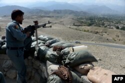 FILE - An Afghan security force member stands at a checkpoint in the Achin district of eastern Nangarhar province, Sept. 28, 2015.