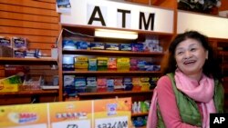 Owner Young Soolee basks in the attention at her small Alliance Center office bulding newsstand on Dec. 18, 2013, in Atlanta, after lottery officials said one of two winning Mega Millions lottery tickets were purchased from her store.