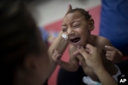 One-year-old Jose Wesley Campos, who was born with microcephaly, cries during a physical therapy session at the AACD rehabilitation center in Recife, Brazil, Sept. 28, 2016.
