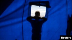 Seorang anak laki-laki pengungsi Kurdi dari Kobani mencoba mengintip sekolah barunya di kamp pengungsi di kota perbatasan Suruc, provinsi Sanliurfa, Turki, 2 November 2014.