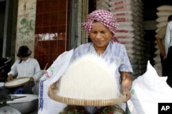 រូបឯកសារ៖ អាជីវករ​ម្នាក់​កំពុង​អ៊ុំ​អង្ករ​នៅ​មុខ​តូប​លក់​អង្ករ​របស់​គាត់​នៅ​ទីក្រុង​ភ្នំពេញ កាលពី​ថ្ងៃច័ន្ទ ទី២៦ ខែ​ឧសភា ឆ្នាំ​២០០៨។ (រូបថត៖ AP/Heng Sinith)