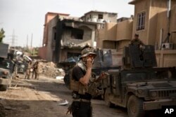 FILE - An Iraqi special forces soldier speaks on the radio as troops move from the Yarmouk neighborhood to take another district from Islamic State militant control in Mosul, Iraq, April 12, 2017.
