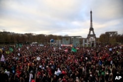 Activists gather near the Eiffel Tower during the COP21, the United Nations Climate Change Conference, in Paris, Dec.12, 2015.
