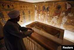 Seorang penjaga melihat lukisa-lukisan kuno Mesir dan sarkofagus di dinding makam firaun muda, Raja Tutankhamun, di Lembah Para Raja di Luxor, Mesir, 31 Januari 2019