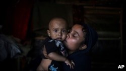 In this Nov. 27, 2017, photo, Mohamed Yaha demonstrates what he saw when soldiers bound the hands of men with nylon rope and blindfolded them with scarves taken from the women when they massacred his village in Myanmar's Rakhine State.