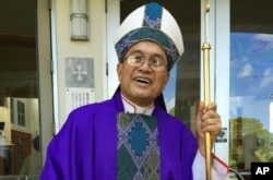 FILE - Archbishop Anthony Apuron stands in front of the Dulce Nombre de Maria Cathedral Basilica in Hagatna, Guam, in November 2014.