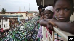 Girls watch a rally for Sierra Leone opposition presidential candidate Julius Maada Bio from their terrace in downtown Freetown, November 15, 2012.