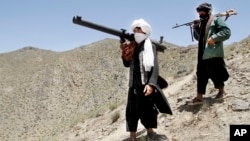 FILE - Afghan Taliban fighters are seen carrying weapons in a May 27, 2016, photo.