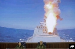 FILE - Colonel General Sergei Surovikin, commander of the Russian forces in Syria (left) and Col. Gen. Sergei Rudskoi of the Russian General Staff, attend a briefing in the Russian Defense Ministry in Moscow, Russia, June 9, 2017.