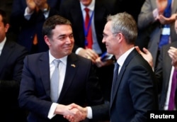 Makedonski ministar vanjskih poslova Nikola Dimitrov se rukuke sa generalnim sekretarom NATO saveza Jensom Stoltenbergom za vrijeme ceremonije potpisivanja protokola o pristupu Makedonije u NATO, Brisel, 6. februar