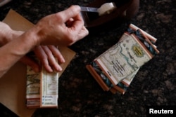 Nancy Silva packages chocolate bars at the Kirikire chocolate factory in Caracas, Venezuela, Oct. 4, 2017.